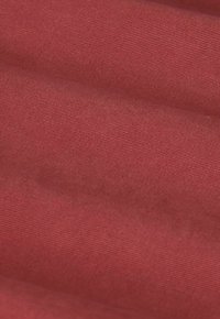 Rode stof met een gladde textuur, voorzien van fijne diagonale ribbels en een subtiele glans, met zachte vouwen en plooien.