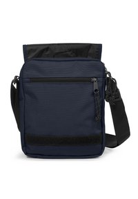 Námorně modrá taška přes rameno vyrobená z odolné tkaniny, s vrchním klopou, přední kapsou na zip a nastavitelným popruhem. Texturovaný povrch a doplněk na suchý zip.