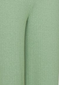 Grüne, gerippte Stoffleggings mit vertikalem Texturmuster, aus weichem Material und glatter Oberfläche. Keine sichtbaren Beschläge oder Akzente.