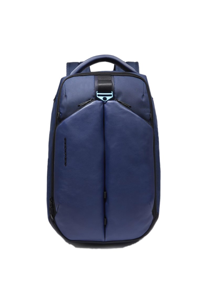 Zaino blu navy con finitura morbida e opaca, caratterizzato da una forma strutturata, fronte piatto e dettagli neri. Scomparti con zip e manico superiore.