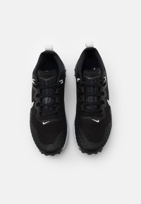 Mustat urheilukengät, joissa on verkkokangas ja valkoiset yksityiskohdat, teksturoitu pohja ja mustat nauhat. Varustettu takana vetokelalla, joka helpottaa pukemista.