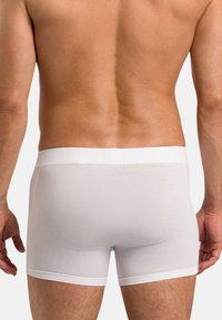White cotton boxer briefs with a soft elastic waistband, fitted design, and smooth texture. Plain without patterns or accents.