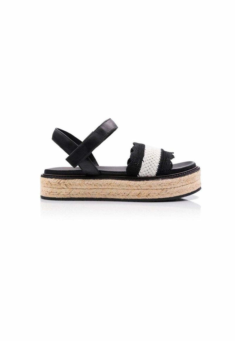 Sandalias de plataforma negras con plantilla de yute trenzado, que presentan una amplia correa tejida en blanco y negro y tiras cruzadas en el tobillo.