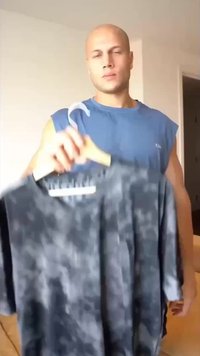 Heren grijze overhemd met korte mouwen en een subtiel gemarmerd patroon, gemaakt van lichtgewicht stof, hangend aan een houten hanger.