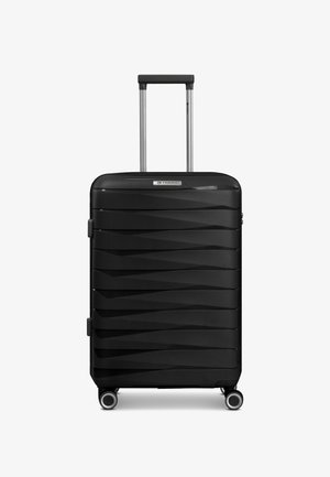 Valise rigide noire à roulettes avec poignée télescopique étendue, rainures horizontales texturées et quatre roulettes pivotantes sur fond blanc.