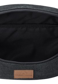Gray fabric bag interior with a black lining, featuring a leather label embossed with "JOHNNY URBAN." Smooth texture, zipper closure.