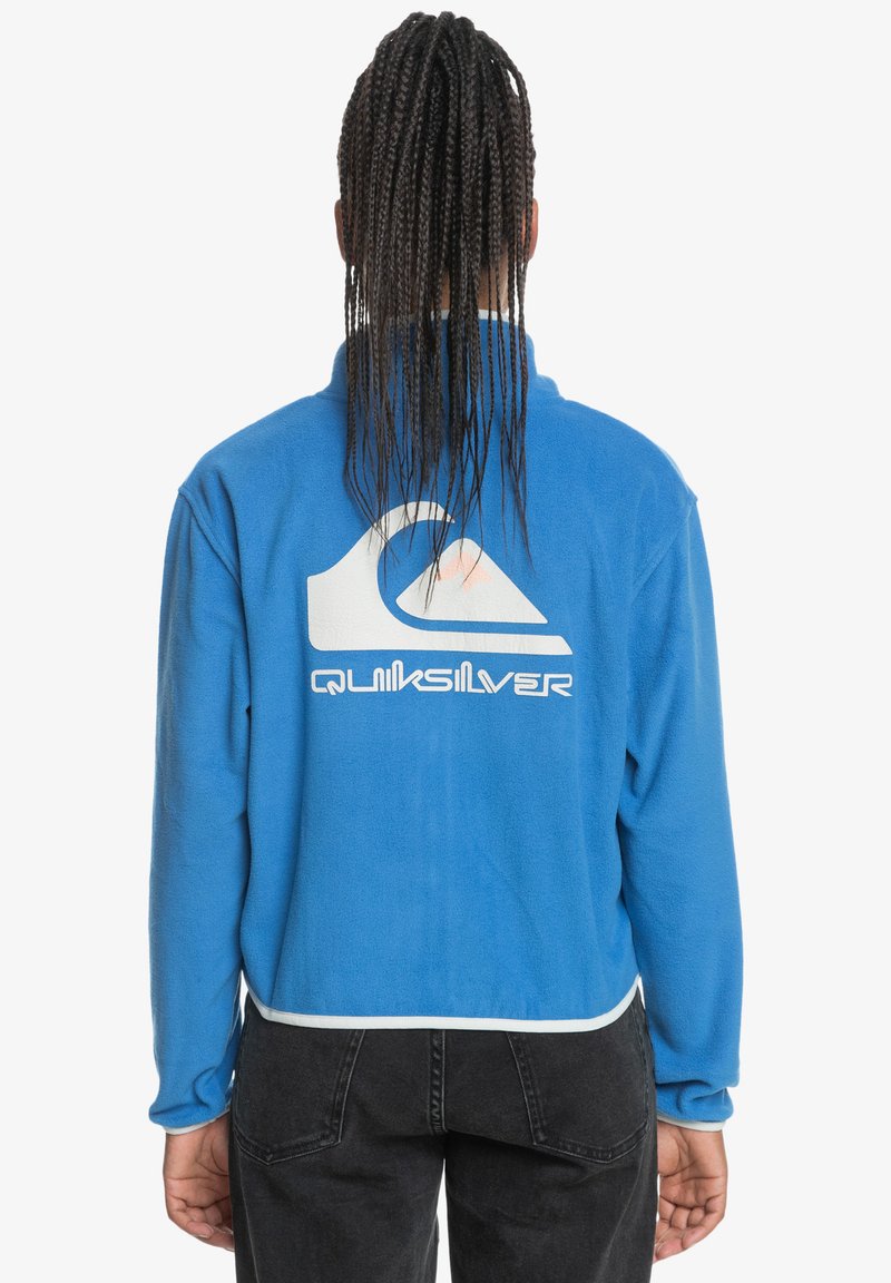 Blue fleece pullover with a high collar, featuring a white Quiksilver logo and contrasting lower trim. Long sleeves with a relaxed fit.