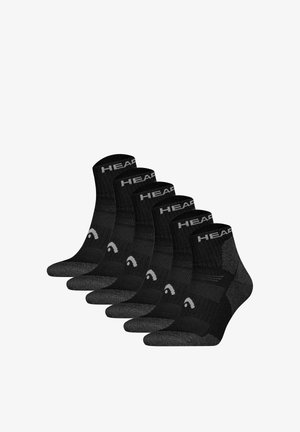 Sechs Paar schwarze Knöchelsocken mit grauen Zehen- und Fersenbereichen und dem Schriftzug HEAD am Bündchen, in einer versetzten Reihe angeordnet.