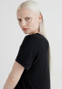 Black short-sleeve t-shirt with a round neckline and a relaxed fit, featuring soft fabric and simple design without embellishments.