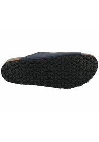 Shoe sole featuring a textured black rubber material with a hexagonal pattern, bordered by a light-colored, cork-like edge.