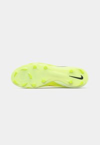 Suela de zapatilla deportiva en amarillo neón con clavos redondeados y un logo de Nike negro cerca del área del dedo del pie, mostrado sobre un fondo blanco.