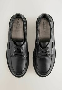 Scarpe in pelle nera con finitura liscia, caratterizzate da un classico design allacciato, punta rotonda e cuciture decorative lungo i lati.
