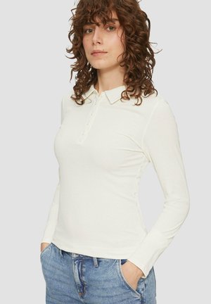 Poloshirt met lange mouwen in off-white ribbed stof met kraag en knoopdetail, gecombineerd met lichtblauwe spijkerbroek.