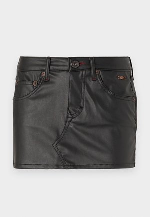 Mustast kunstnahkmini seelikut, millel on sobiv disain, ees taskud ja pronksist aksessuaarid. Omab nähtavat õmblust, mis lisab tekstuuri.