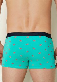 Boxer shorts blu acqua con un design aderente, caratterizzati da un motivo ripetuto di fette di anguria e una vita scura.