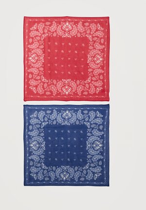 Røde og blå firkantede bandanaer med hvide paisley- og blomstermønstre, lagt fladt på en lys baggrund.
