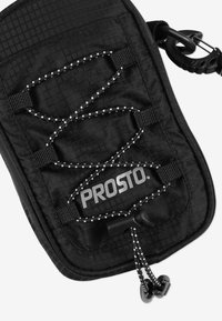 Czarna torba z tkaniny o wzorze w diamenty, z elastycznym sznurkiem i białymi akcentami. Zawiera logo "PROSTO" oraz trwałe detale sprzętowe.