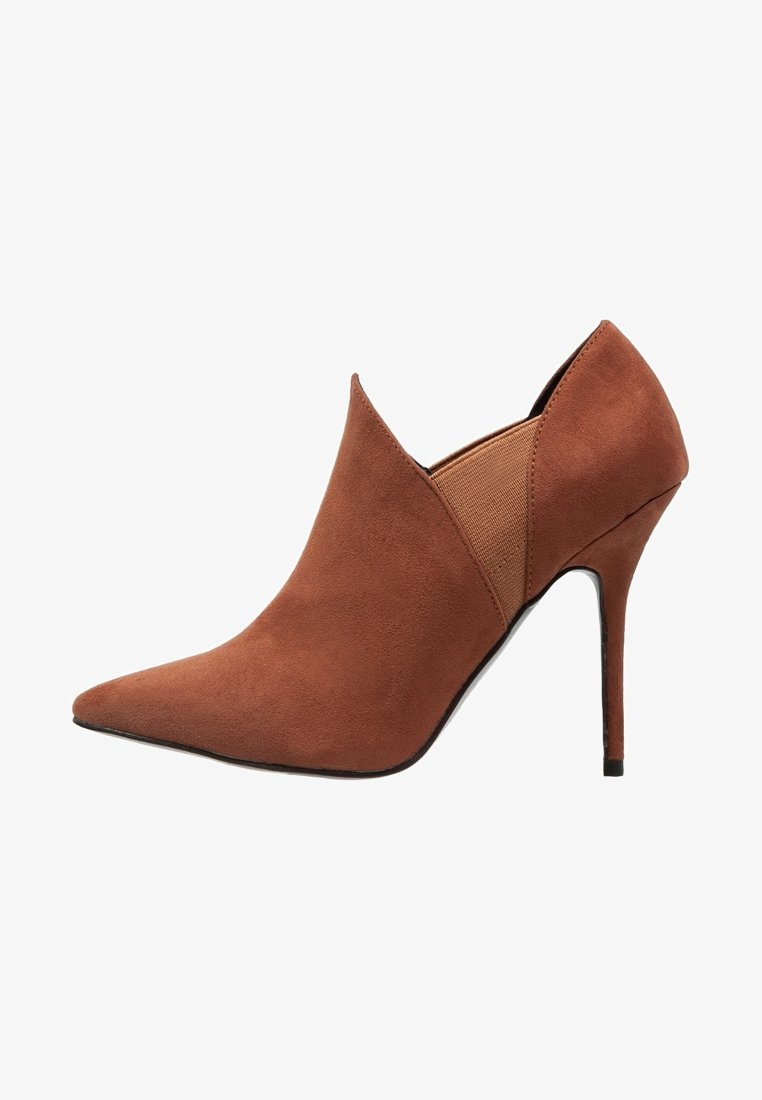 Stivaletto alla caviglia in suede marrone con punta a punta, tacco a stiletto sottile e pannello laterale elastico.