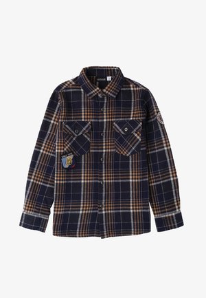 Navy- und braun kariertes Flanellhemd mit Knopfleiste, zwei Brusttaschen und einem Emblem auf der linken Tasche. Lange Ärmel mit Knopfmanschetten.