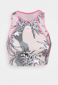 Crop top sportivo con motivi floreali neri e strisce su uno sfondo rosa chiaro, con bordi rosa e dettaglio del logo.
