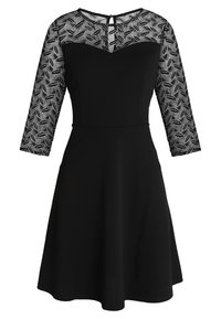 Svart klänning med en figursydd överdel och utsvängd kjol. Trekvartsärmar med ett mönstrat, genomskinligt overlayer. Nyckelhålsdetalj på ryggen.