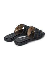 Chanclas negras con parte superior de tejido texturizado, diseño de punta abierta, suela plana y plantilla acolchada. Nombre de la marca "ALMA EN PENA" visible.