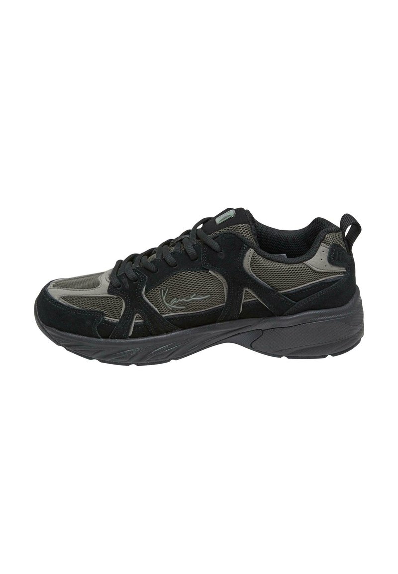 Chaussure de sport noire en matériaux mesh et daim, avec une surface texturée, des lacets, un design structuré et une semelle en caoutchouc durable.