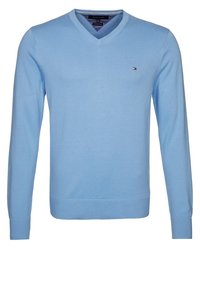 Jasnoniebieski, długi sweter z dekoltem w serek, wykonany z dzianiny. Posiada małe logo na piersi oraz ściągacze przy rękawach i dolnym brzegu. Gładka faktura.