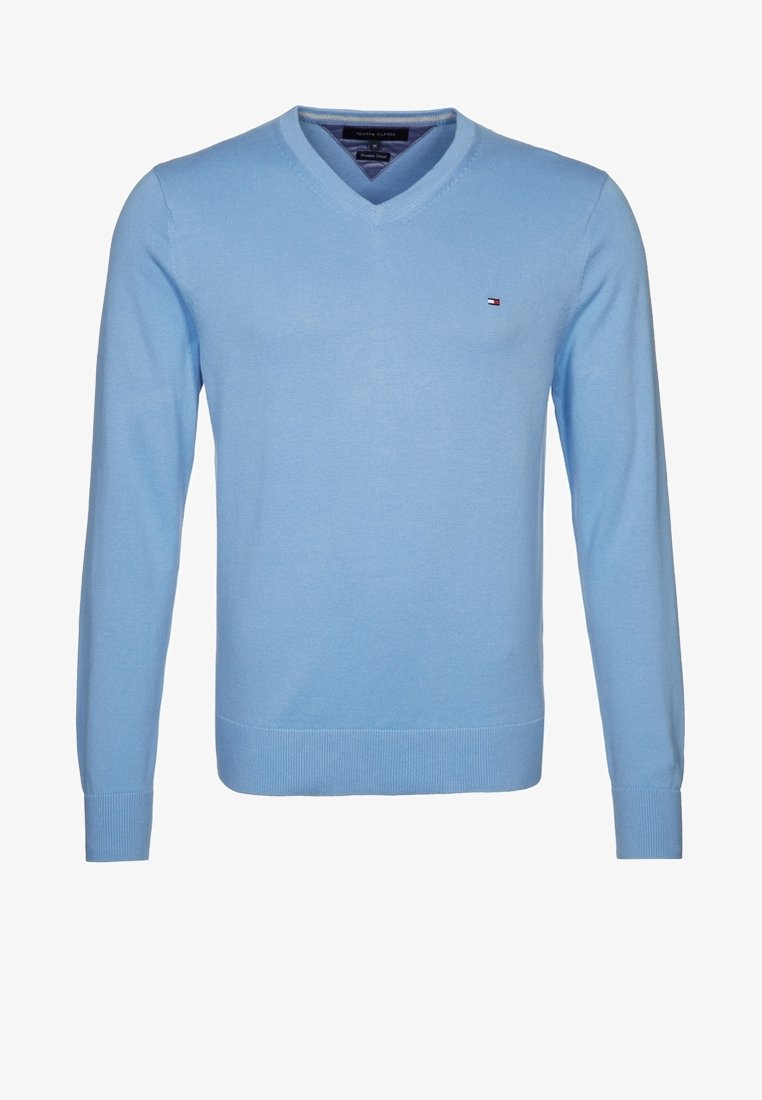 Jasnoniebieski, długi sweter z dekoltem w serek, wykonany z dzianiny. Posiada małe logo na piersi oraz ściągacze przy rękawach i dolnym brzegu. Gładka faktura.