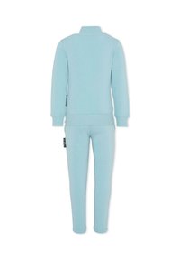 Błękitny dres z miękkiego materiału; posiada zapięcie na zamek na kołnierzu, długie rękawy oraz zwężane spodnie z elastycznymi mankietami i boczną marką.