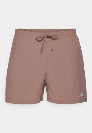 Light brown athletic shorts with an elastic waistband, drawstring, and a small gray logo on the lower left side. Smooth fabric texture.