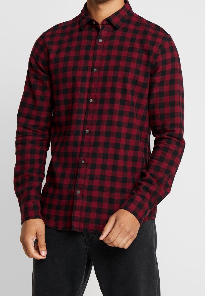 Langarmige geruite shirt in rood en zwart met knoopsluiting, kraag en getailleerd ontwerp. De stof lijkt zacht en heeft een gemiddeld gewicht.