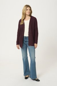 Maroon, textured cardigan with an open front, worn over a light top and flared jeans, featuring long sleeves and casual black flats.