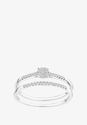 Sidabrinis žiedų komplektas, kuriame yra trys juostos: viena su centrine apvalia grupine aiškių brangakmenių klasteriu, kitos puošia mažesni akmenys.