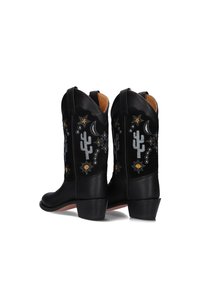 Zwarte leren cowboylaarzen met geborduurde cactus, sterren en manen; heeft gestapelde hakken en treklussen voor eenvoudig aantrekken.