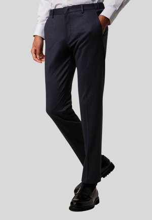 Marineblaue formelle Hose mit tailliertem Schnitt, glatter Textur und subtiler Oberflächenbeschaffenheit. Mit Gürtelschlaufen und flacher Frontgestaltung.