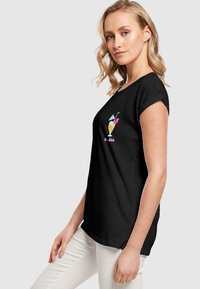Black short-sleeve T-shirt featuring a colorful cocktail graphic on the front. Made of soft fabric with a relaxed fit.