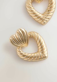 Gold heart-shaped earrings featuring a textured, twisted design. The surface is shiny with ridges, enhancing their detailed appearance.