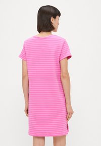 Rožinė medvilninė suknelė su baltais dryžiais, trumpomis rankovėmis, apvalia kaklo iškirpte ir šoninėmis iškarpomis. Audinys turi lygų tekstūrą ir laisvą siluetą.