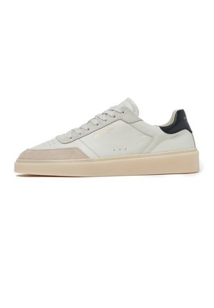 Sneaker bianca in pelle basse con punta in pelle scamosciata beige, suola crema, lacci grigi e linguetta del tallone nera con logo dorato.