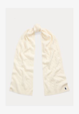 Bufanda de punto trenzado color crema atada con un nudo suelto, con un pequeño logo bordado en azul oscuro en un extremo.