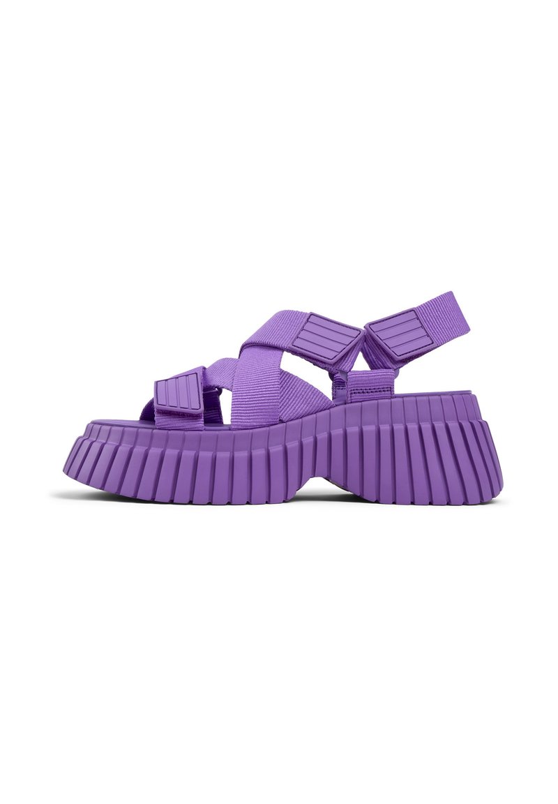 Sandali platform viola con suola spessa e scanalata, dotati di cinghie larghe e elementi decorativi, realizzati in materiale resistente per comfort e supporto.