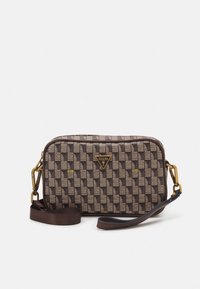 Brun og beige ternet crossbody-taske med guldfarvet hardware og Guess-logo foran, med justerbar rem.