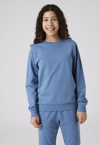 Felpa blu in morbido tessuto strutturato; presenta un collo rotondo, polsini e orlo a costine; abbinata a pantaloni coordinati.