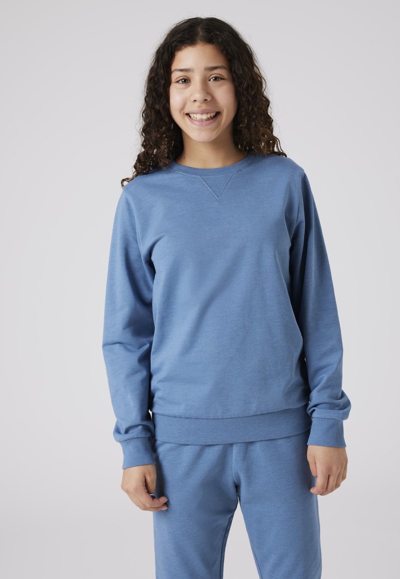 Sweatshirt bleu en tissu doux et texturé ; avec un col rond, des poignets et un ourlet côtelés ; associé à un pantalon assorti.