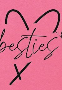 Różowa tkanina z napisem "besties" w czarnym kursywnym foncie, ozdobiona sercami wokół tekstu. Projekt ma gładką teksturę.