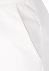 Țesătură de bumbac alb, cu o textură fină, având o buzunar lateral și un model subtil de striuri diagonale. Design curat, bine croit.