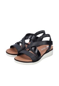 Sandales pour femmes noires avec bretelles croisées, détail tressé, semelle intérieure marron rembourrée et semelle plateforme blanche.