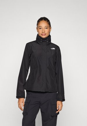 Svart vanntett jakke med høy krage, frontglidelås, to side lommer og North Face-logo på venstre bryst. Lettvektig design.