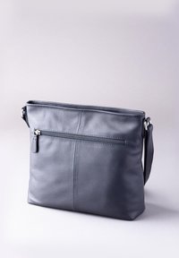 Gray leather crossbody bag with a zippered front pocket, smooth texture, minimalist design, and adjustable strap.